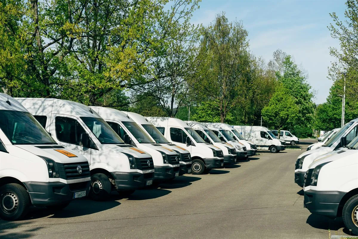 A fleet of white vans parked in a row